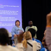 Students presenting with hands raised